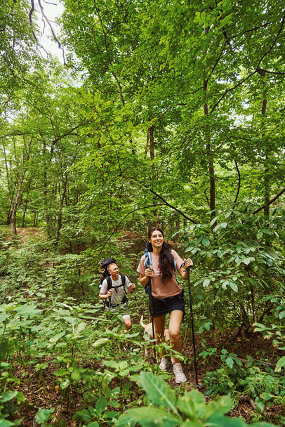 Onnellinen nuori pari nauttii kiipeilystä metsässä - Valokuva, kuva