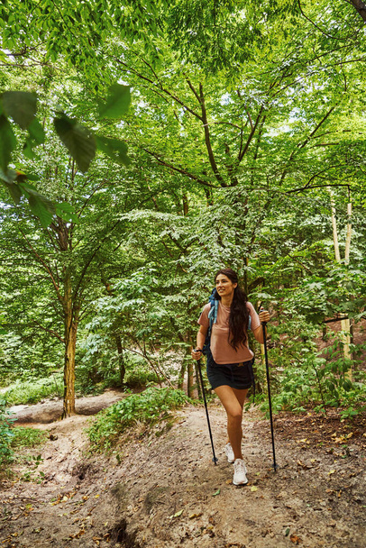 Щаслива спортивна леді йде сама в лісі
 - Фото, зображення