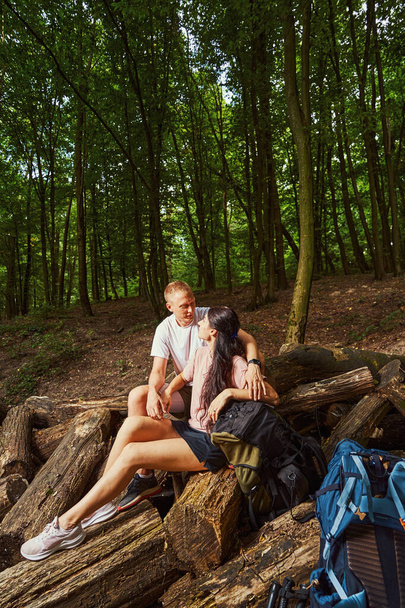 Boldog fiatal pár pihenés közben túrázás az erdőben - Fotó, kép