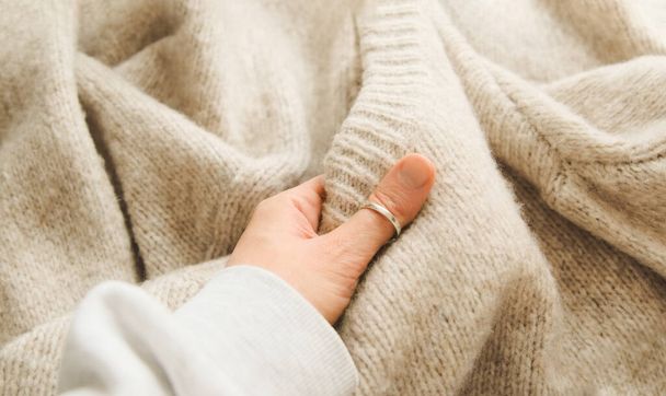 Hand touching knitted wool cloth or warm fluffy sweater. Handcraft knitting woolen fabric surface.  - Zdjęcie, obraz