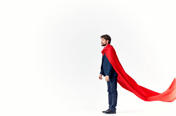 man in suit with red cloak hold hand above head superhero light background - Foto, immagini