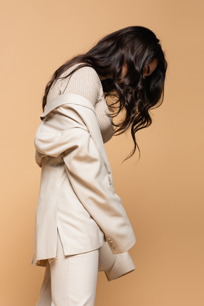 brunette young model in turtleneck and blazer posing isolated on beige - Foto, afbeelding