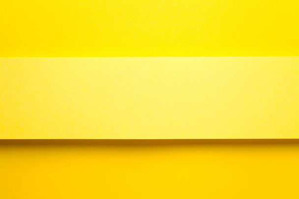 Yellow paper banner on yellow paper background. Top view. Copy space. Flat lay - Zdjęcie, obraz