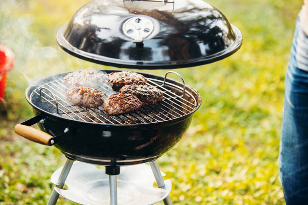 Close-up foto van vlees op grill. Lekker eten koken. Vrienden picknicken op warme zomerdag - Foto, afbeelding