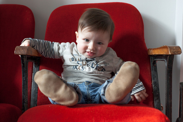 хлопчик сидить на стільці
 - Фото, зображення