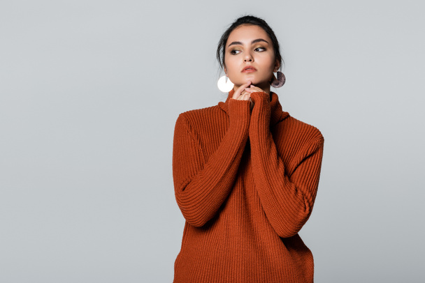 fiatal nő meleg pulóverben néz félre elszigetelt szürke  - Fotó, kép