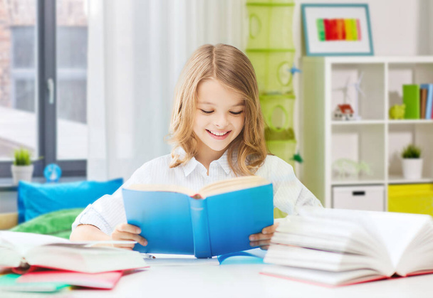 happy smiling student girl reading book at home - Zdjęcie, obraz