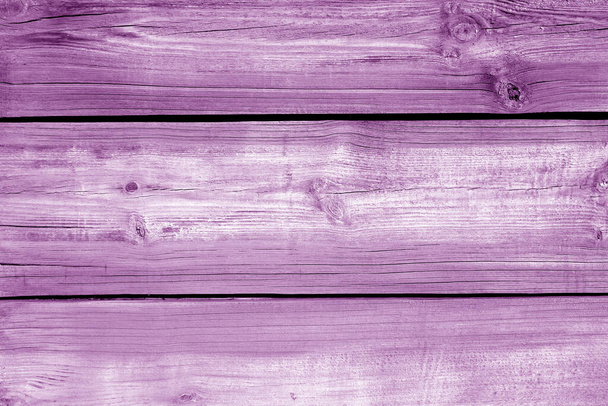 Muur gemaakt van ongeslepen verweerde houten planken in paarse kleur. Abstract achtergrond en textuur voor design. - Foto, afbeelding