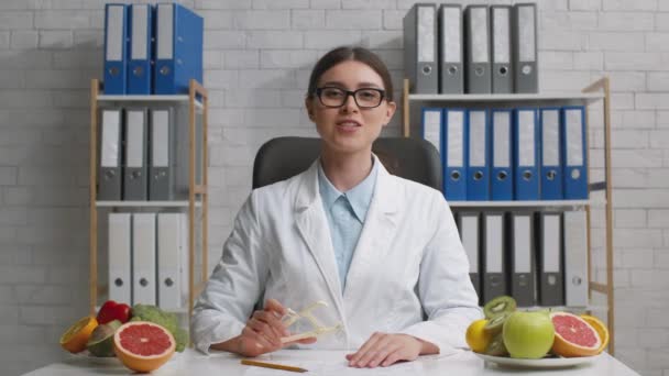Inzoomen portret van positieve jonge vrouwelijke arts voedingsdeskundige tonen caliper, uitnodigen om vet index van je lichaam te controleren - Video