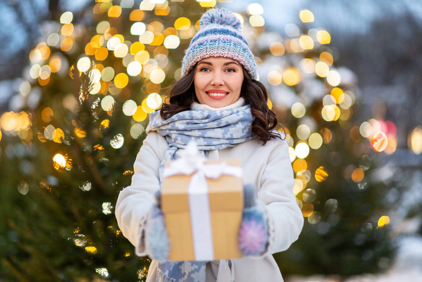 happy woman with christmas gift over lights - Foto, imagen