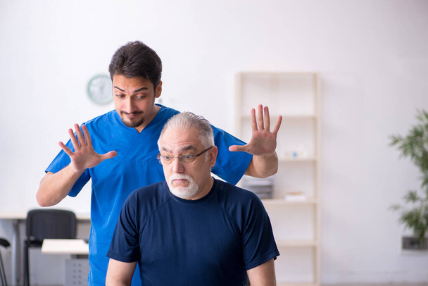 Old man visiting young male doctor - Foto, imagen