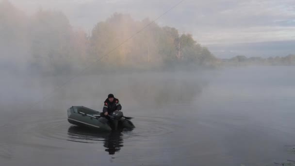 Gomel, BELARUS - SEPTEMBER 4, 2021: kauçuk bir teknede sabah sisli bir motorla bir balıkçı - Video, Çekim