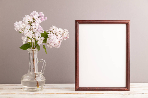 Wooden frame with lilac flower in glass on gray pastel background. side view, copy space, mockup, template, spring, summer minimalism concept. - Photo, Image