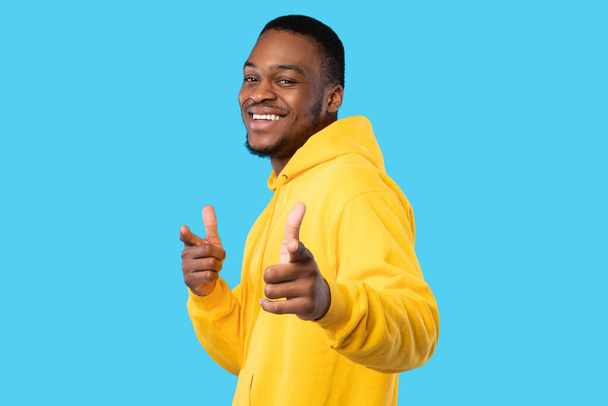 Afro-Amerikaanse man wijzend vingers op camera op blauwe achtergrond - Foto, afbeelding