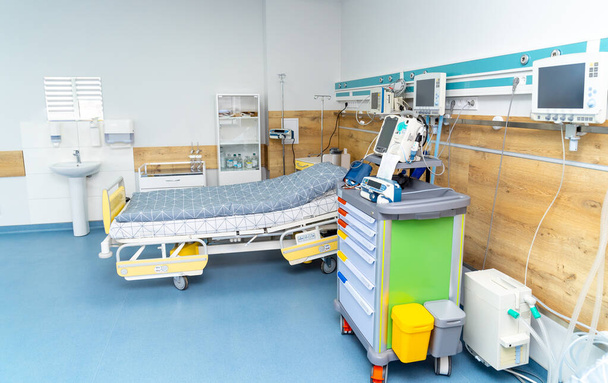 Hospital ward with beds and medical equipment ready for intensive recovery, modern technology. Wooden panels with emergency buttons. - Foto, imagen
