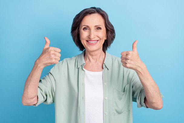 Photo portrait senior woman showing thumb-up gesture smiling isolated pastel blue color background - Foto, Imagen