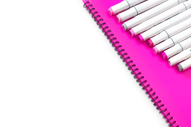 professional multi-colored markers are lying on a pink folder. - Photo, Image