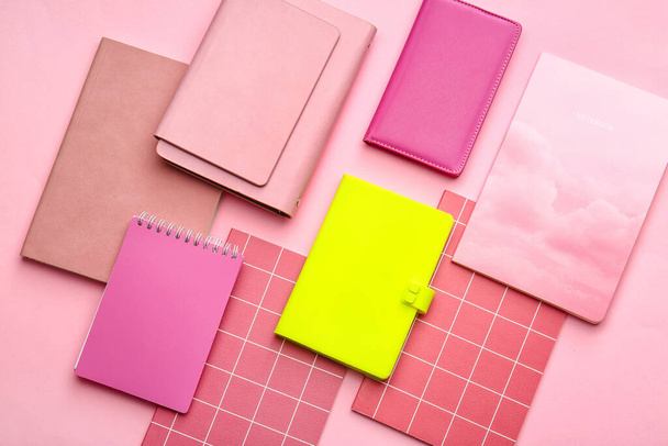 Cuaderno amarillo entre los rosados sobre fondo de color. Concepto de singularidad - Foto, Imagen