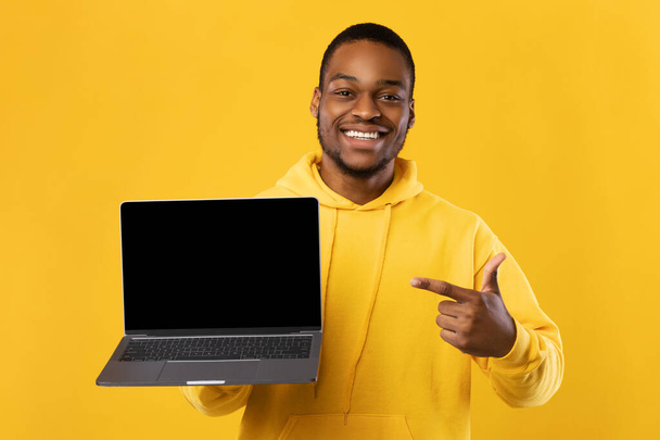Black Guy Showing Laptop Computer Blank Screen Over Yellow Background - Φωτογραφία, εικόνα