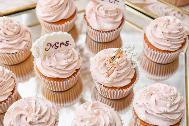 Cupcakes saborosos e anéis de casamento na bandeja - Foto, Imagem