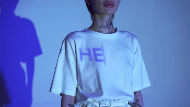 Oříznutý pohled na nápis Hello na tričku ženy na modrém pozadí  - Záběry, video