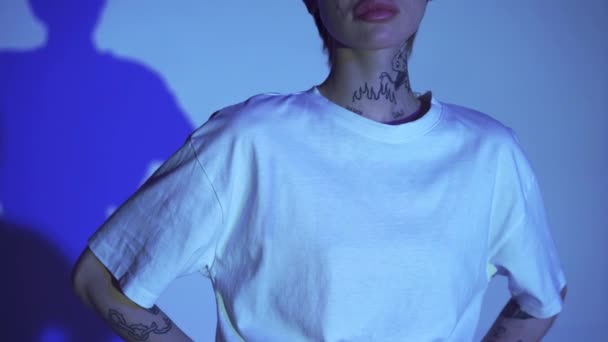 Περικοπή άποψη της δύναμης επιστολόχαρτα σε t-shirt της γυναίκας με τατουάζ σε μπλε φόντο  - Πλάνα, βίντεο