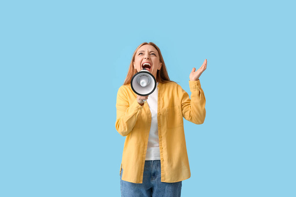 Mujer madura enojada gritando en megáfono sobre fondo de color - Foto, Imagen