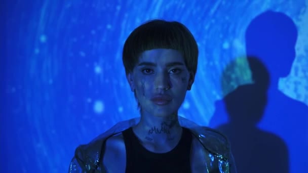 Powolny ruch stylowej kobiety chodzącej na abstrakcyjnym niebieskim tle  - Materiał filmowy, wideo
