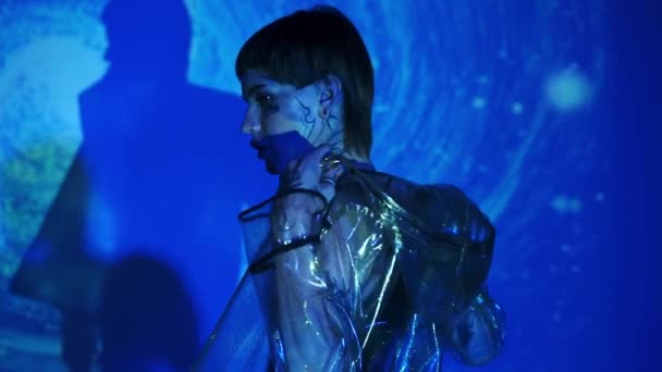 Vue latérale du modèle tatoué qui enlève sa veste sur fond bleu abstrait  - Séquence, vidéo