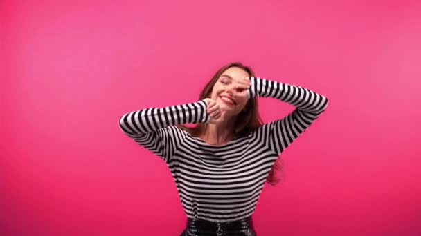 veselá žena v pruhované košili s dlouhým rukávem tanec izolované na růžové - Záběry, video