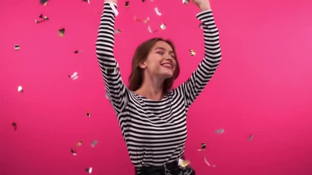 zpomalený pohyb šťastné ženy tančící pod konfety na růžové - Záběry, video