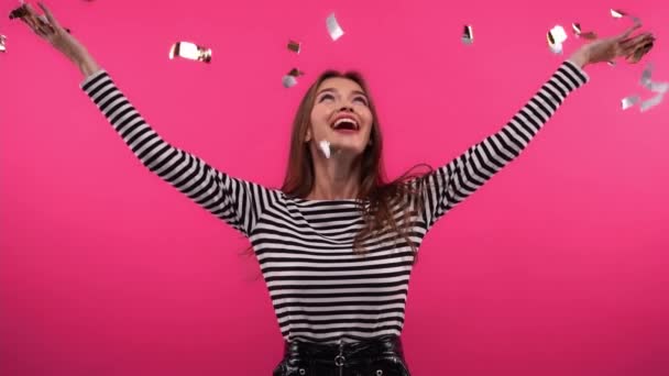 mujer emocionada vomitando confeti espumoso en rosa - Imágenes, Vídeo