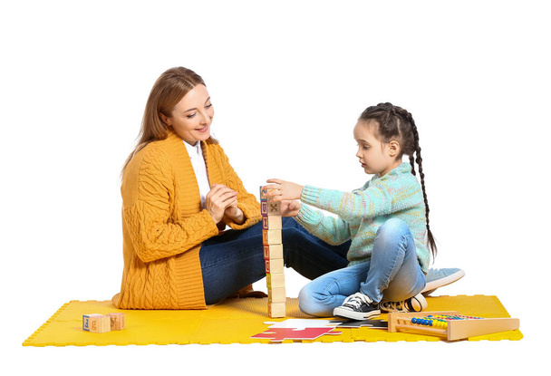 Naispsykologi työskentelee autistisesta häiriöstä kärsivän tytön kanssa valkoisella taustalla - Valokuva, kuva