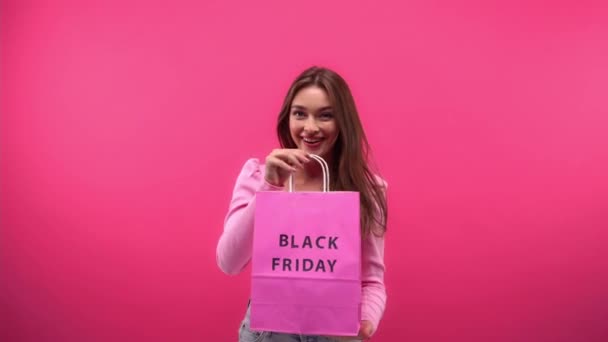 freudige Frau mit Einkaufstasche und Parfüm auf rosa - Filmmaterial, Video