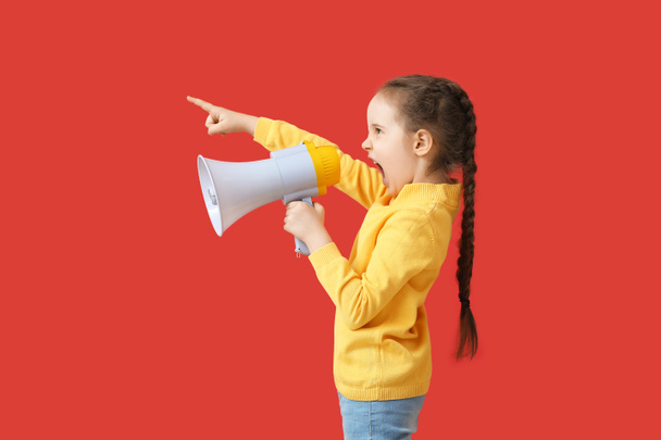 Маленькая девочка кричит в мегафон на цветном фоне - Фото, изображение