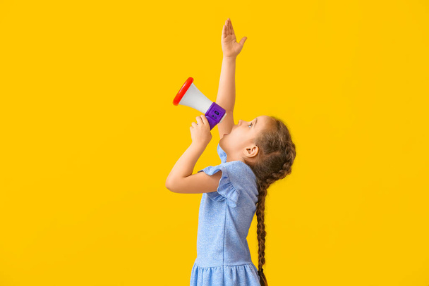 Маленька дівчинка кричить на мегафон на кольоровому фоні
 - Фото, зображення