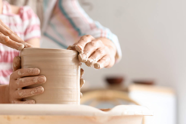 Kleines Mädchen mit ihrer Mutter, die zu Hause Keramiktopf herstellt, Nahaufnahme - Foto, Bild