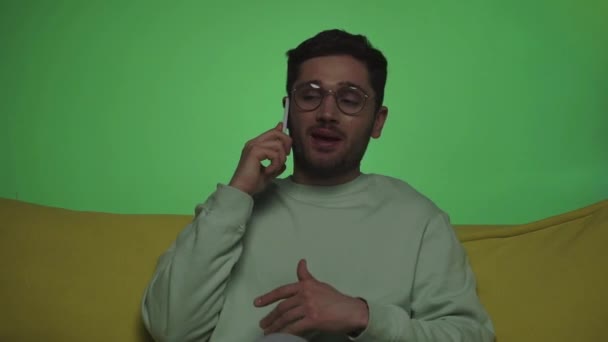 cámara lenta del hombre hablando en el teléfono inteligente y el gesto aislado en verde - Metraje, vídeo