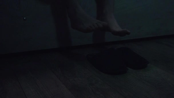 cropped view of man getting up from bed and putting on slippers at night - Footage, Video