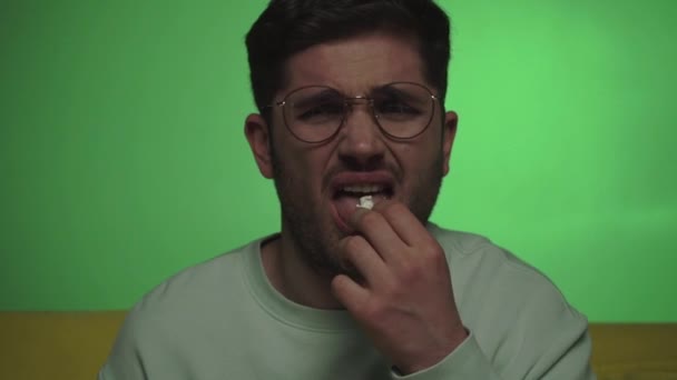 homme se sentant dégoûté et grimaçant tout en mangeant pop-corn insipide sur vert - Séquence, vidéo