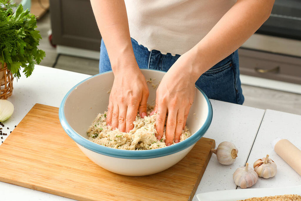 Nainen ruoanlaitto turska kyljykset pöydässä keittiössä - Valokuva, kuva
