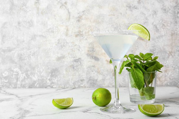 Glass of tasty margarita cocktail on light background - Valokuva, kuva