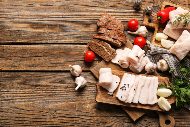 Board with salted lard, bread and fresh vegetables on wooden background - Valokuva, kuva