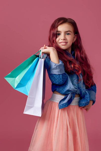 little caucasian child girl holds shopping bags - Fotoğraf, Görsel