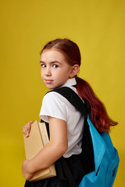 милий щасливий школярка з рюкзаком і книгою
 - Фото, зображення