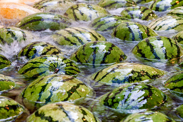 Close up fresh ripe wet watermelons vegetable department agriculture supermarket sale. Rainy weather background. - Photo, Image
