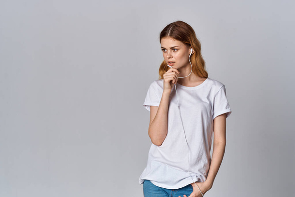 Woman in white t-shirt listening to music - Foto, imagen