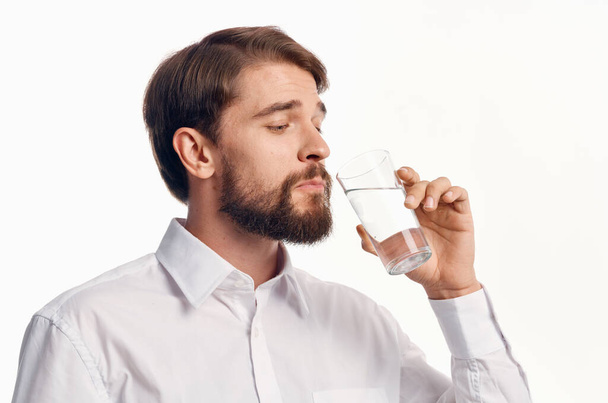 handsome man drinking water on light background. High quality photo - Photo, Image