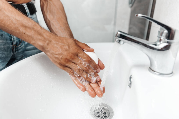 Мужчина моет руки с мылом в раковине, крупным планом фото - Фото, изображение