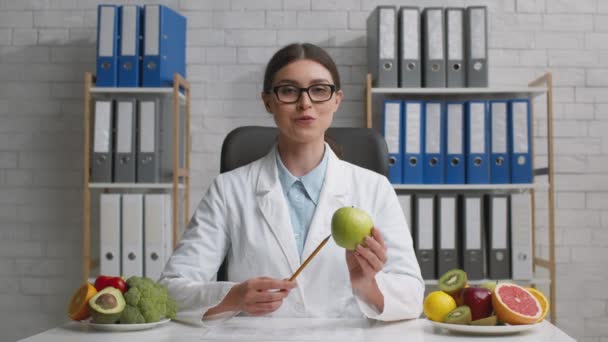 Online voedingsvoorlichting. Zoom in portret van vriendelijke jonge professionele vrouw voedingsdeskundige praten met camera - Video